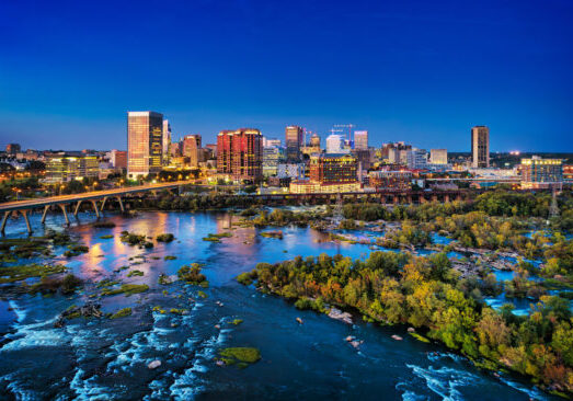 Richmond Skyline Aerial At Dusk With River And Rapids Downtown Richmond skyline aerial at dusk with 9th street bridge, James River, rapids, and islands in the foreground.
